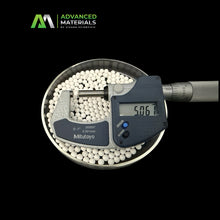 White spherical beads measured inside a metal dish with a Mitutoyo digital micrometer over them, on a black background. Advanced Materials by Vivara Scientific logo is visible in the top left.